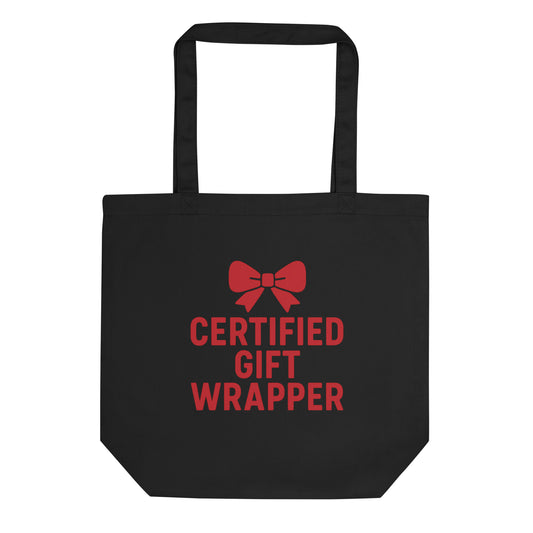 Black tote bag with red text and bow graphic on a white background