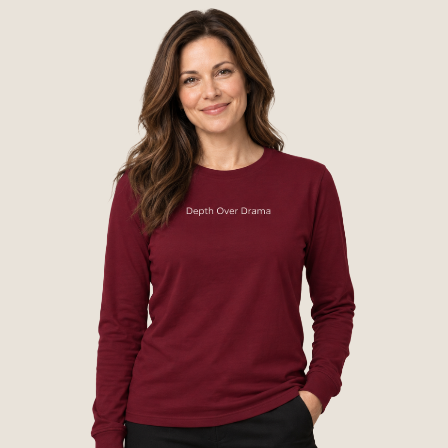 Woman wearing a maroon long sleeve tee with Depth Over Drama centered on the upper chest