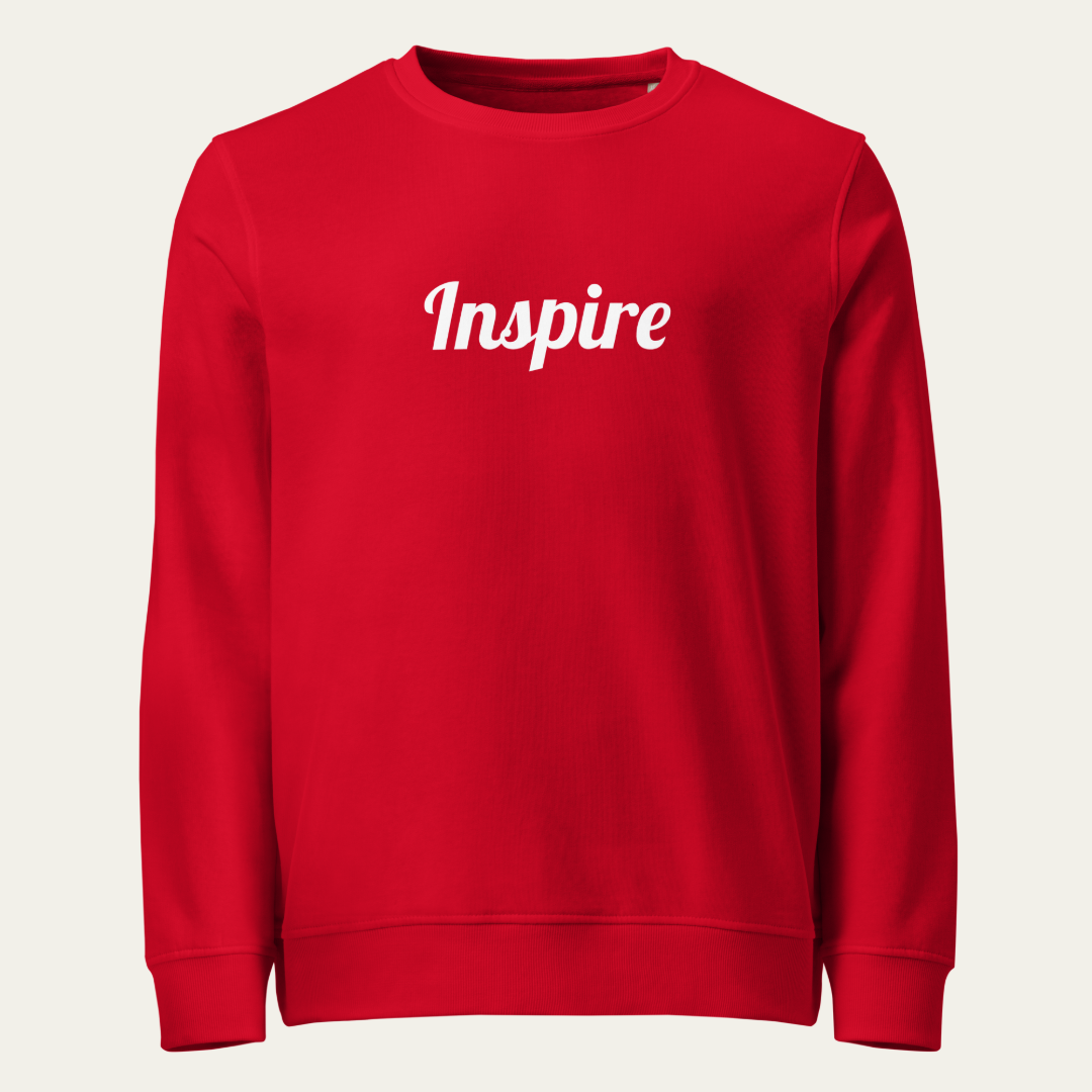 A red crewneck sweatshirt with the word 'Inspire' printed in white cursive across the chest, displayed on a light beige background.