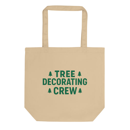 Beige tote bag with 'Tree Decorating Crew' text and Christmas tree icons on a white background