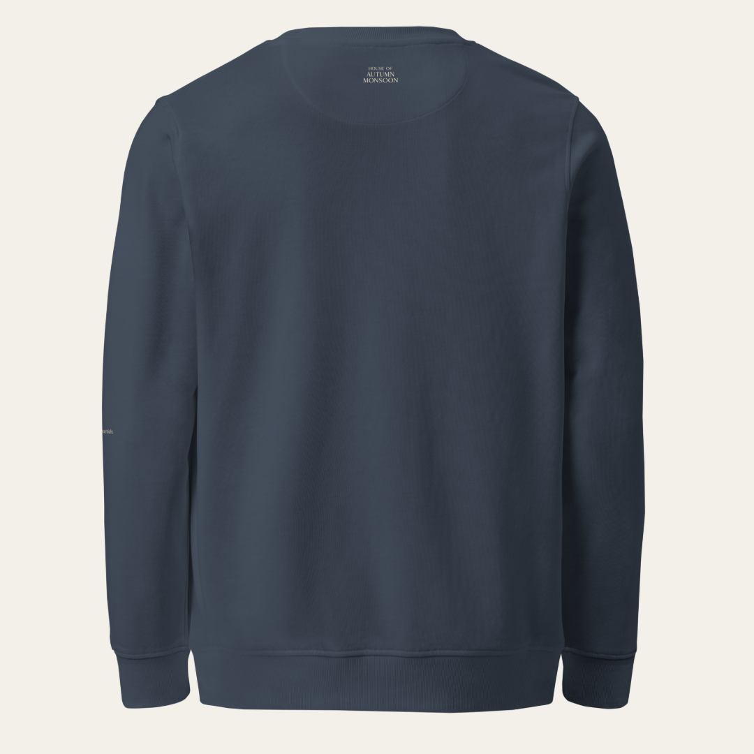 A dark navy blue crewneck sweatshirt shown from the back, photographed flat against a light off-white background.