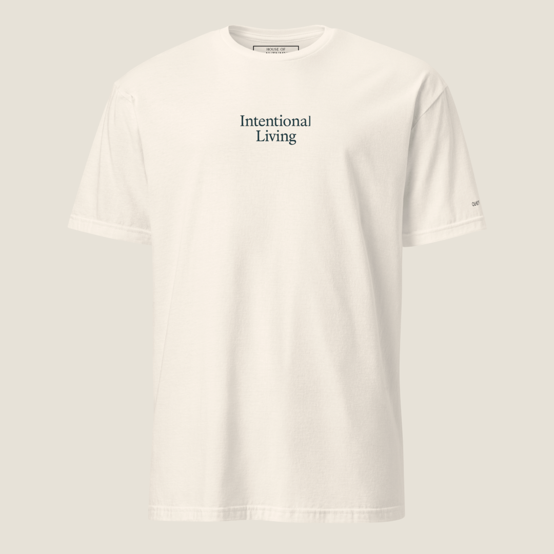 Front of cream t-shirt. Intentional Living printed on chest area with text on left sleeve.