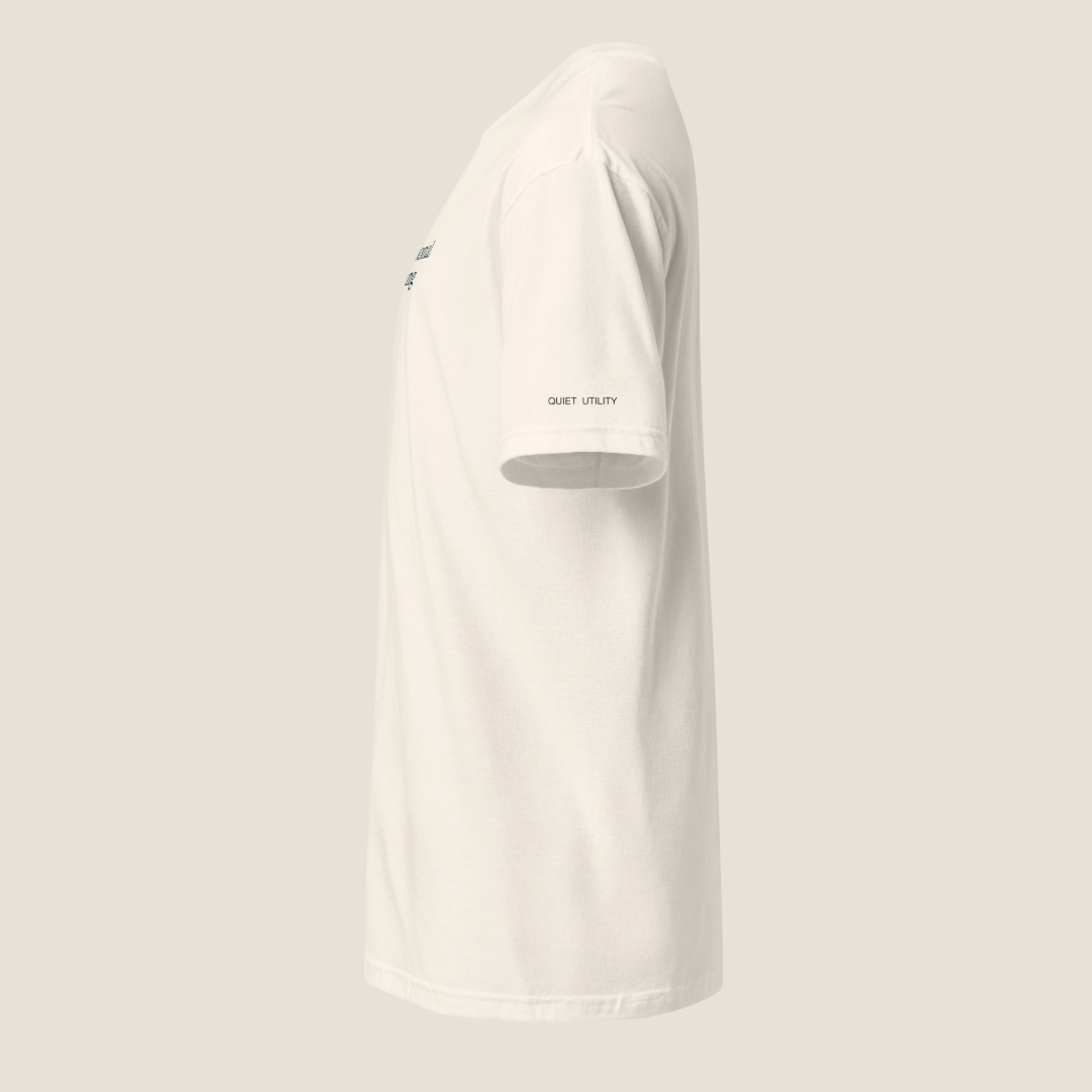 Side view of a cream t-shirt. "QUIET UTILITY" on bottom of left sleeve.