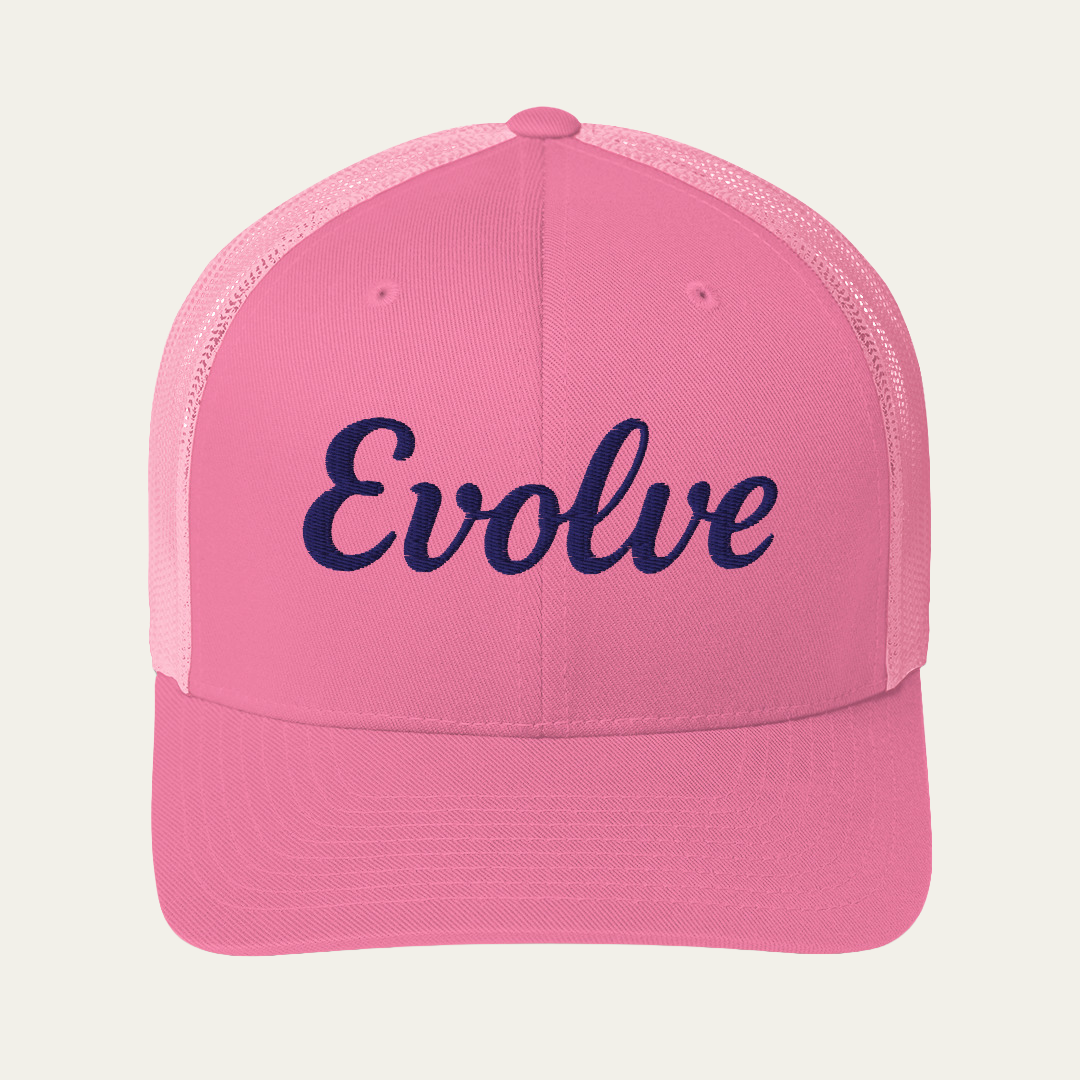 A pink trucker-style cap with the word 'Evolve' embroidered in navy script across the front, shown against a light cream background.