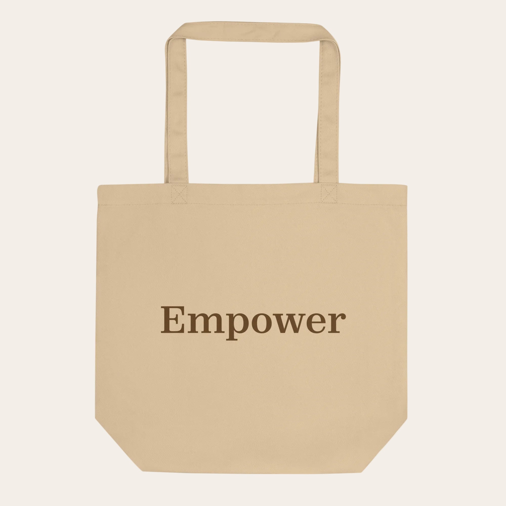 Beige tote bag with 'Empower' text on a white background
