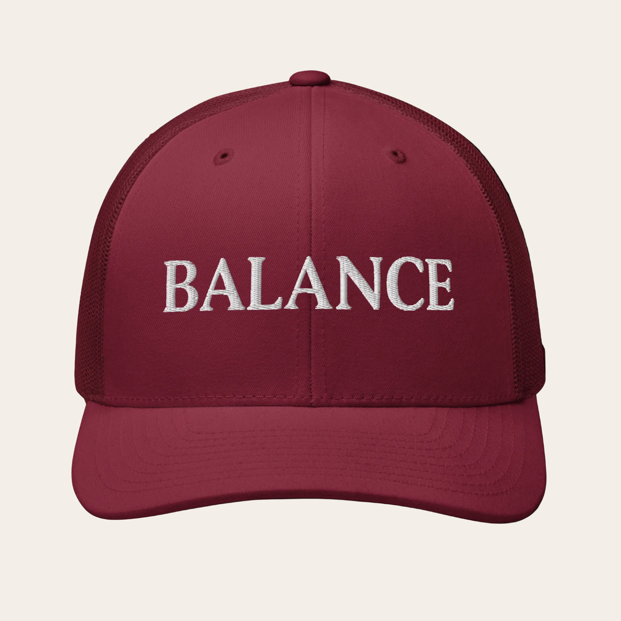 Maroon cap with 'BALANCE' text on a beige background
