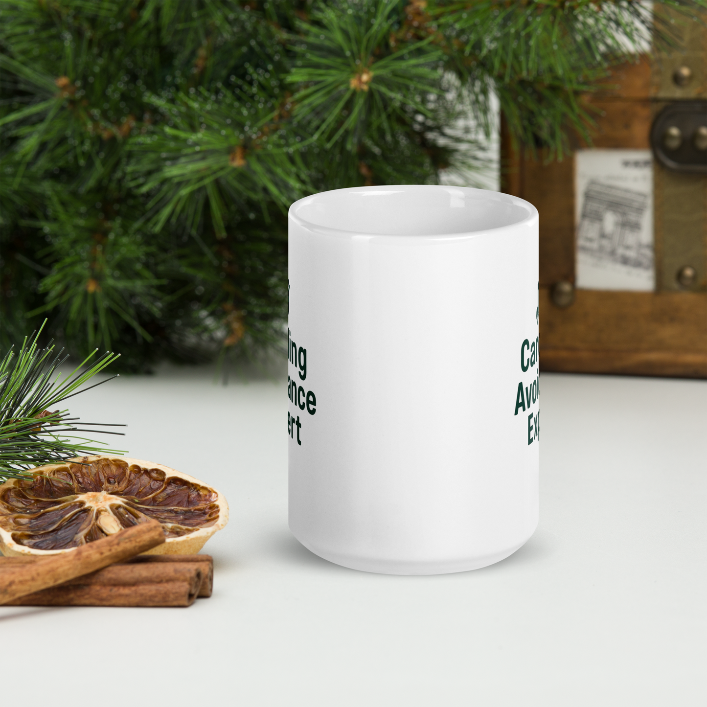 White mug with text on a surface with Christmas decorations