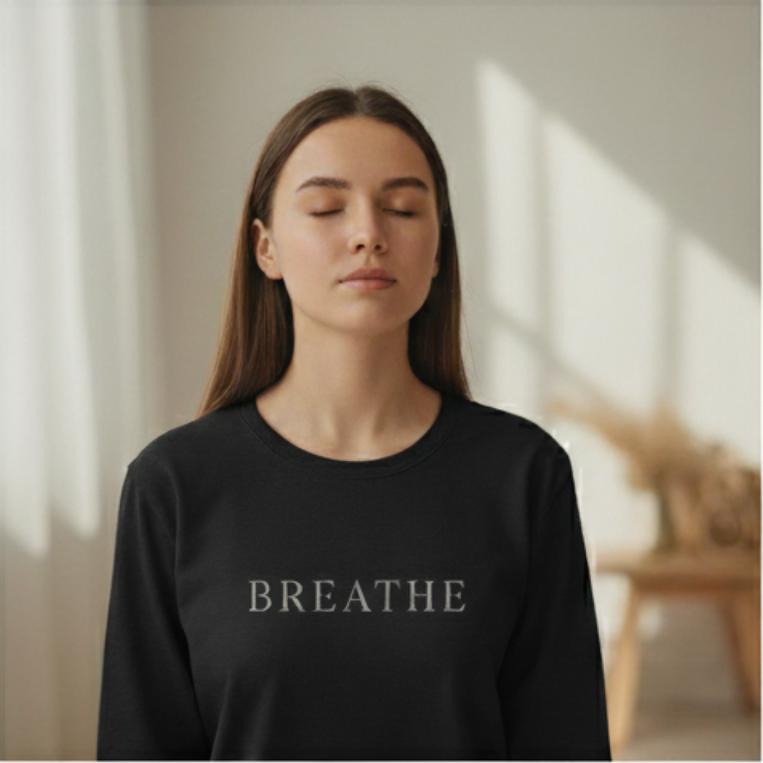 Woman with eyes closed wearing a black tee with the word "Breathe"
