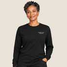 Woman in black pants and a black long sleeve t-shirt that say CARRIED, NOT CRUSHED  on the upper left chest. 