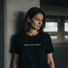 Woman wearing a black t-shirt with 'Death Over Drama' text in an underground parking garage.