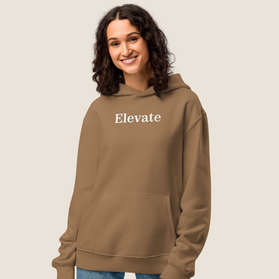 Woman wearing a vintage brown hoodie with "Elevate" text on chest.