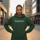 Person wearing a green hoodie with 'Empower' text in an urban setting