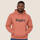 Man wearing a dusty rose hoodie with "Inspire" across the chest.