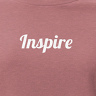 Mauve t-shirt with 'Inspire' text on a white background