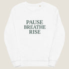 White sweatshirt with 'PAUSE BREATHE RISE' text on a white background