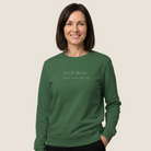 Woman wearing a bottle green Still Here Crewneck Sweatshirt