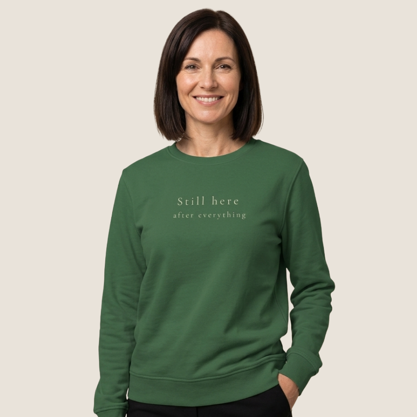 Woman wearing a bottle green Still Here Crewneck Sweatshirt