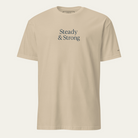 Khaki t-shirt with "Steady & Strong" on chest. Text on left sleeve