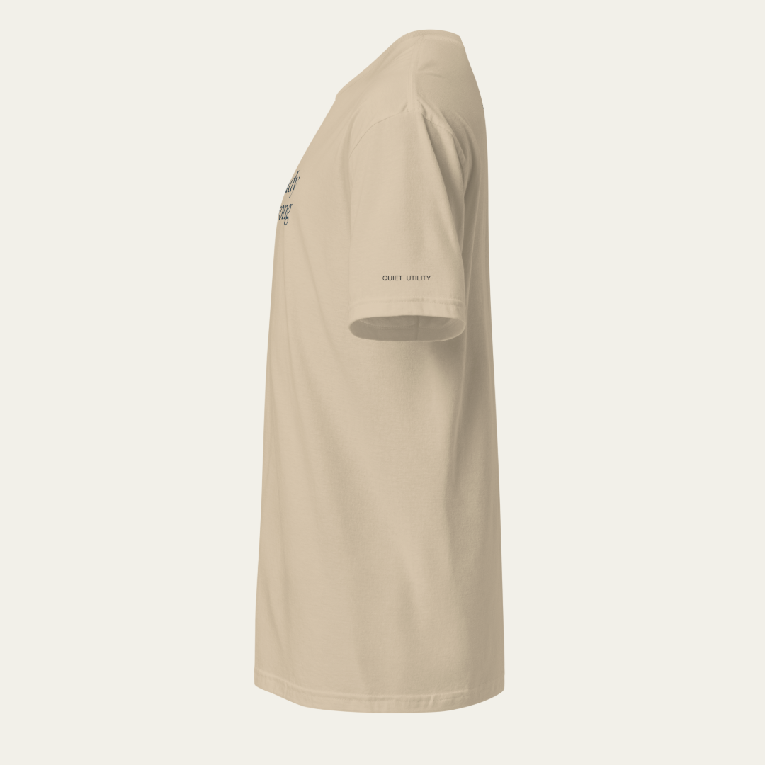 Side view of a khaki tee. "QUIET UTILITY" in printed at the bottom of the sleeve