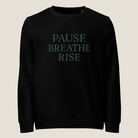 Black sweatshirt with 'PAUSE BREATHE RISE' text in white on a white background