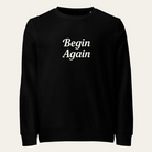 Black sweatshirt with "Begin Again" on the front.