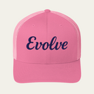 A pink trucker-style cap with the word 'Evolve' embroidered in navy script across the front, shown against a light cream background.