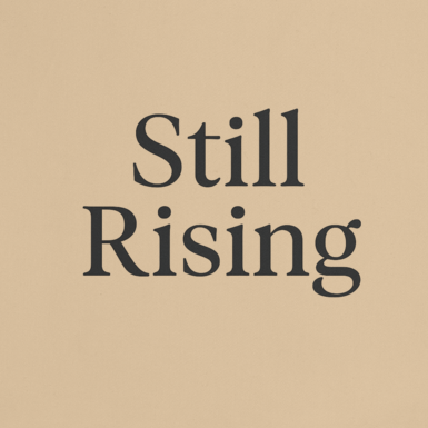 Beige tote bag with 'Still Rising' text on a white background