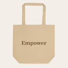 Beige tote bag with 'Empower' text on a white background