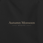 Black tote bag with 'Autumn Monsoon' branding on a white background