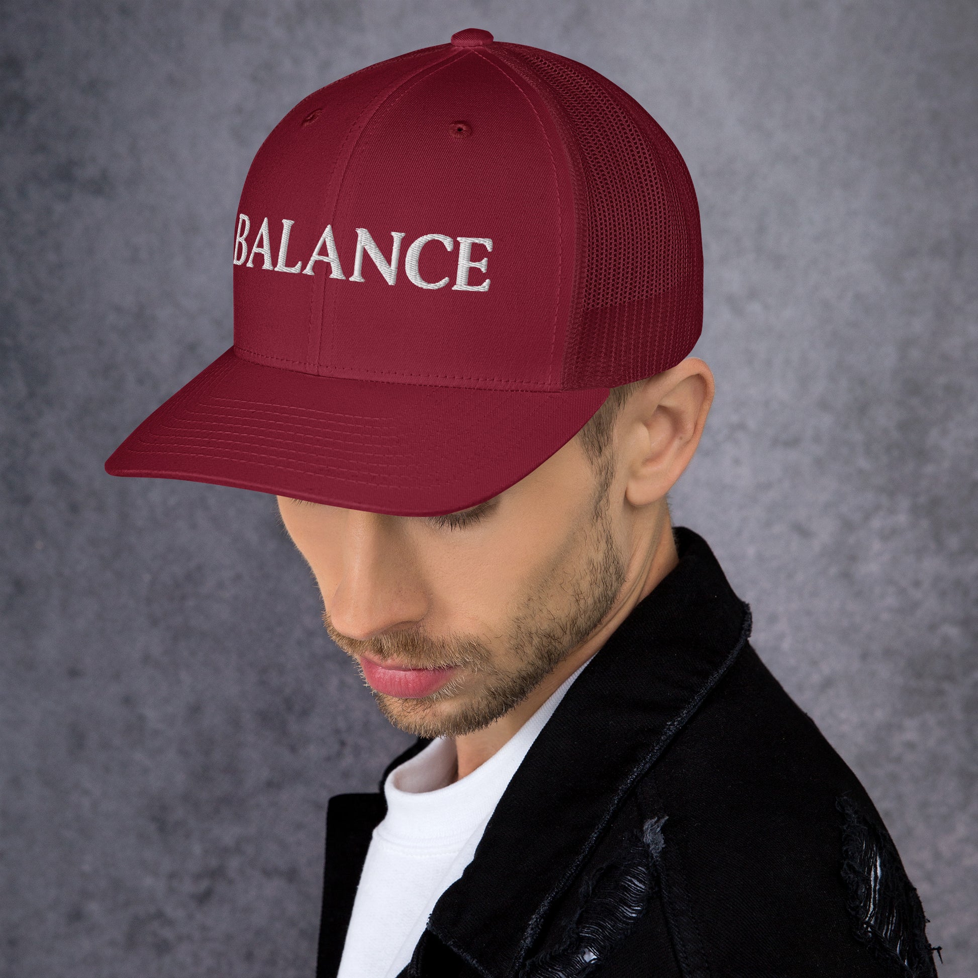 Man wearing a red cap with 'BALANCE' text on a gray background