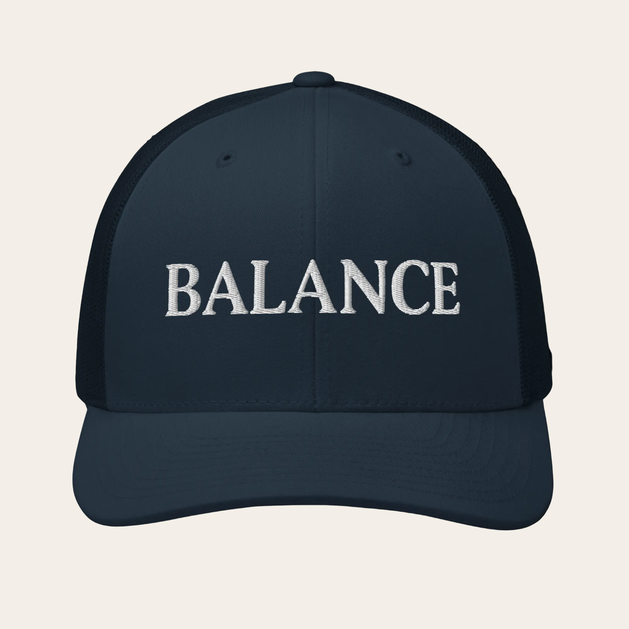 Navy blue cap with 'BALANCE' text on a beige background