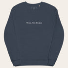 Navy blue sweatshirt with 'Worn, Not Broken' text on a white background