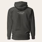 Dark gray hoodie with text 'CARRIED, NOT CRUSHED' on the back against a white background