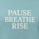 Teal t-shirt with 'PAUSE BREATHE RISE' text on a white background